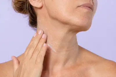 Mature Woman Applying Moisturizing Cream on Neck Skin - Clinical Dermatology Photo