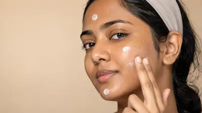 Young Woman Applying Facial Sunscreen Cream on Face - Clinical Stock Photo