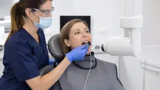 Dentist Preparing Patient for Bitewing Dental X-Ray Procedure - Clinical Stock Photo