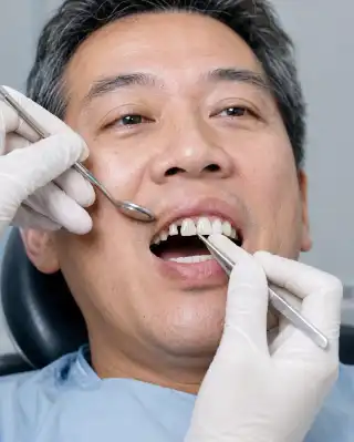 Dentist Fitting Anterior Dental Bridge for Patient in Clinic