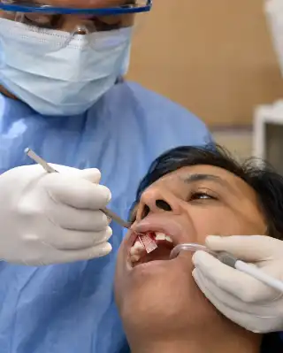 Dental Surgeon Performing Bone Graft Procedure For Implant Site - Clinical Stock Photo