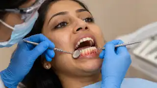 Dentist Examining Patient Gums for Gingivitis with Dental Tools