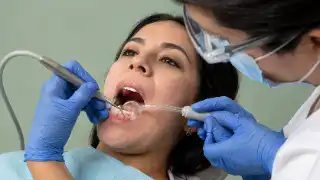 Female Patient Receiving Deep Dental Cleaning Treatment From Dentist