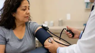Doctor Measuring Blood Pressure of Female Patient in Clinic