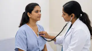 Female Doctor Examining Patient Heart Using Stethoscope - Cardiology Stock Photo